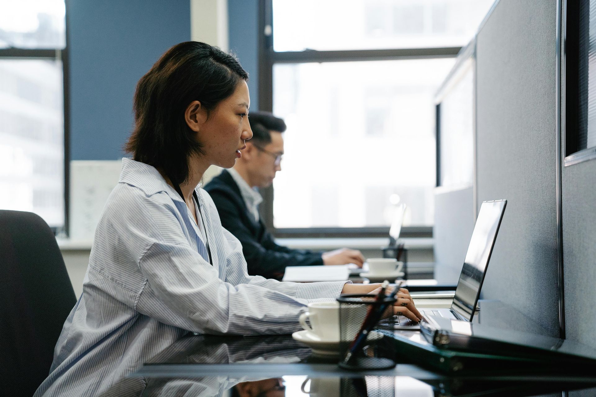 People working on laptops in a bright office meeting room