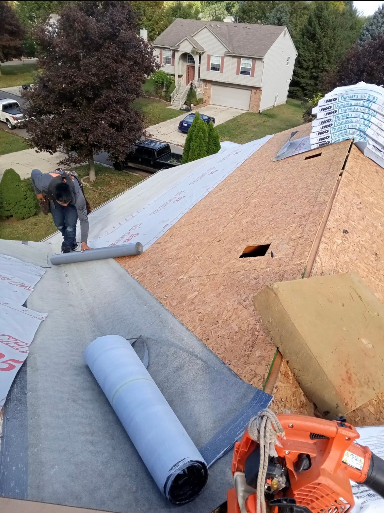A man is working on the roof of a house.