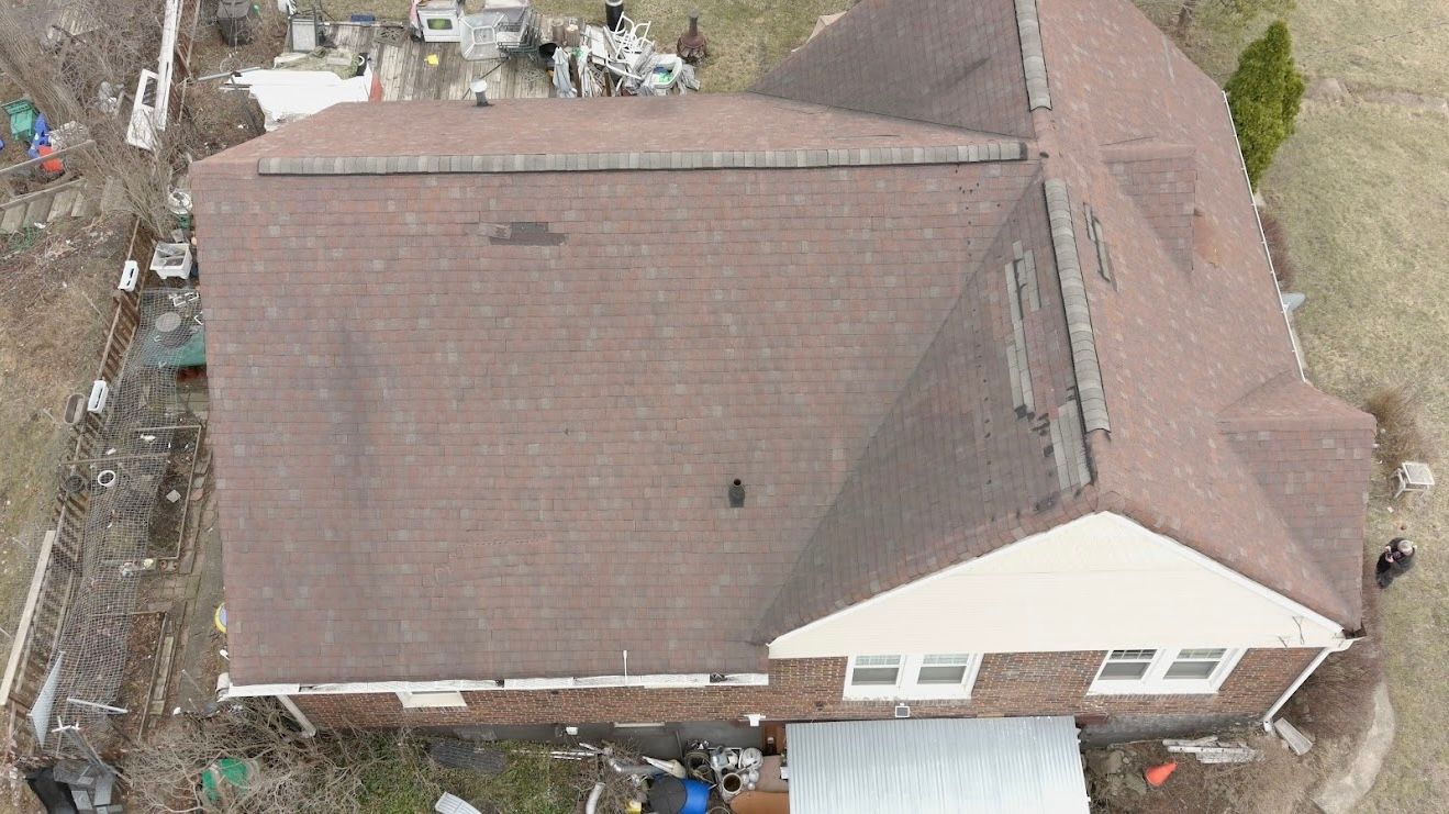 An aerial view of a brick house with a brown roof.
