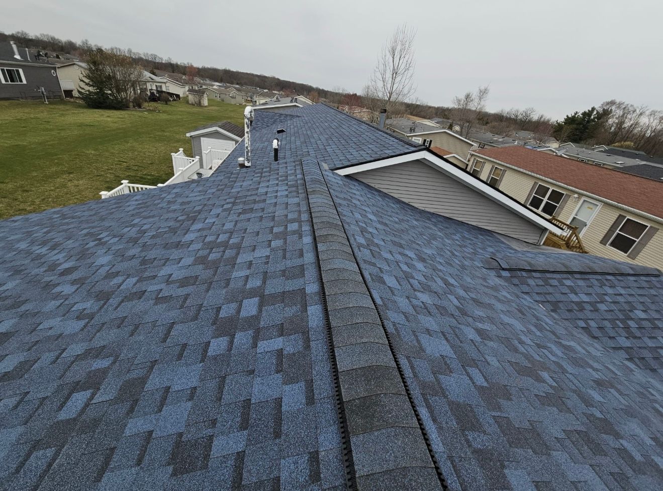 The roof of a house with a blue shingle roof.