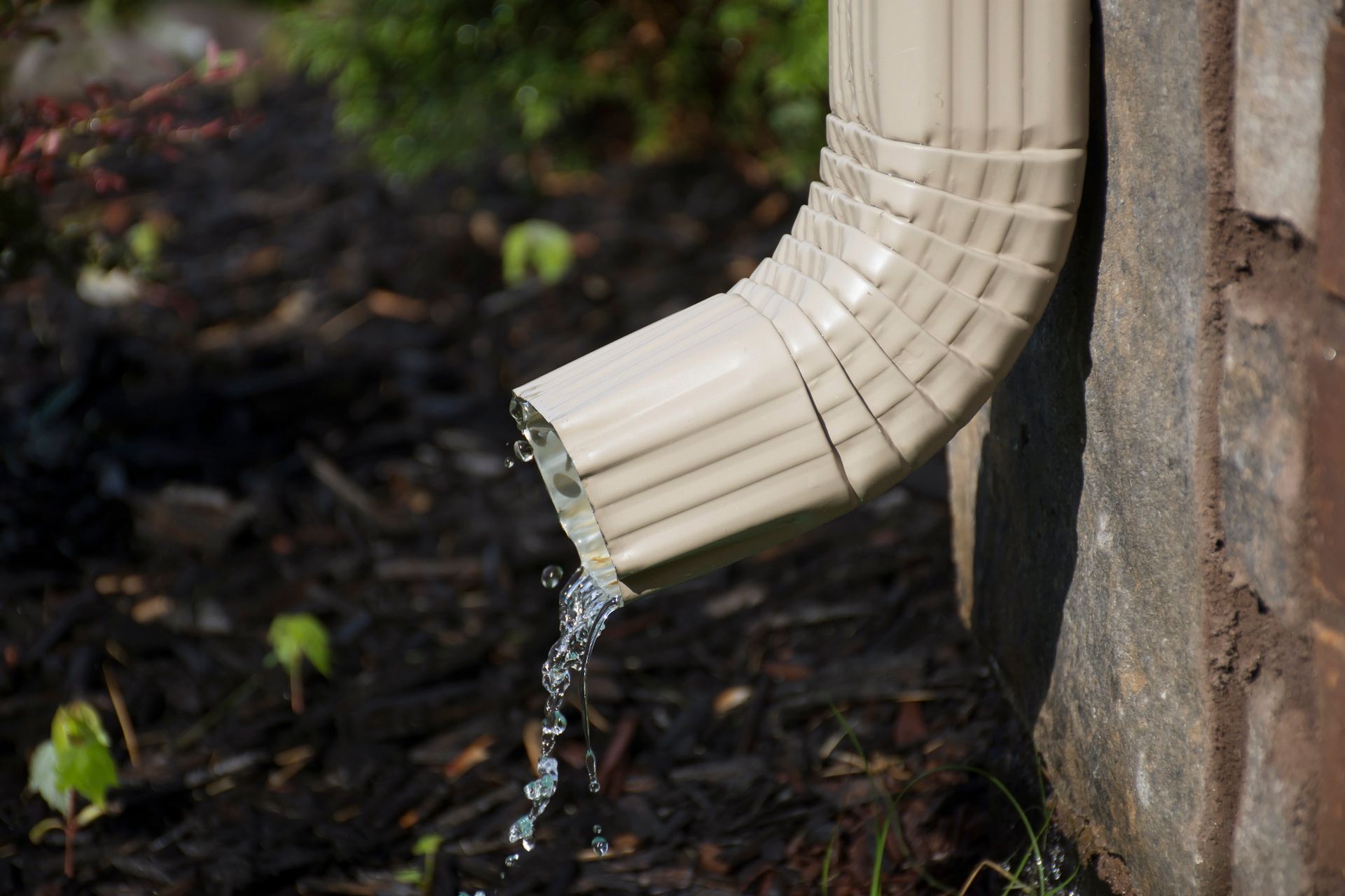 A close up of a drain pipe with water coming out of it