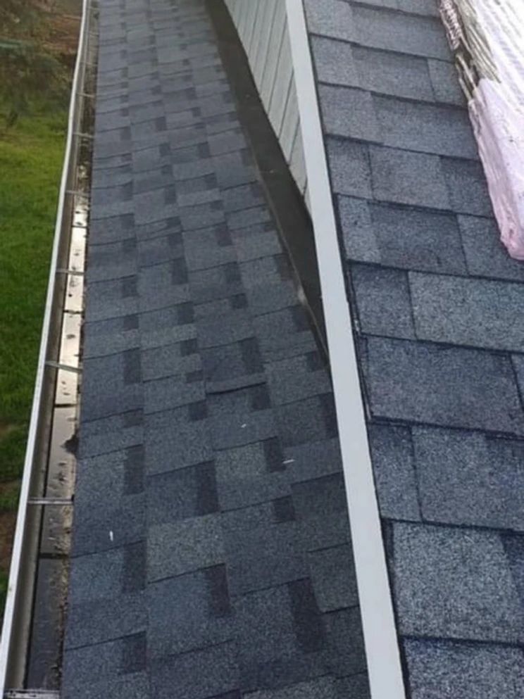 A close up of a gutter on the side of a house.