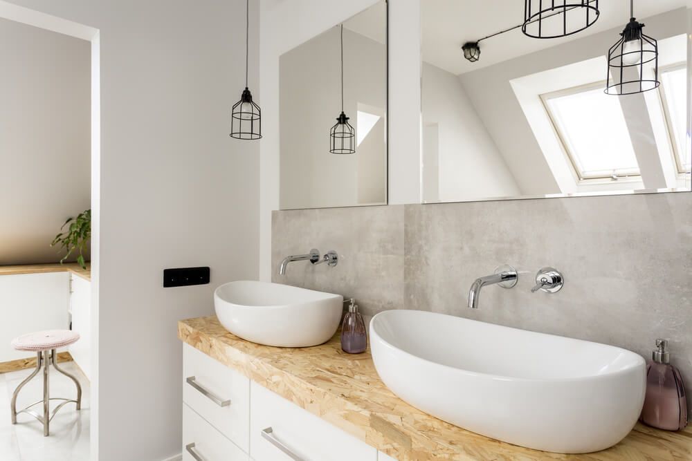 Modern bathroom with white sinks, light wood counter, large mirror, and pendant lights — Fast Glass & Glazing In Barraba, NSW