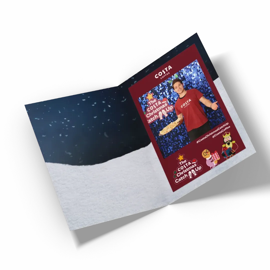 Costa Coffee branded photo wallet open. The interior shows a slot to hold a photo. A Christmas-themed Costa Coffee photo is inserted into the wallet. Produced by Ghelani Studios.