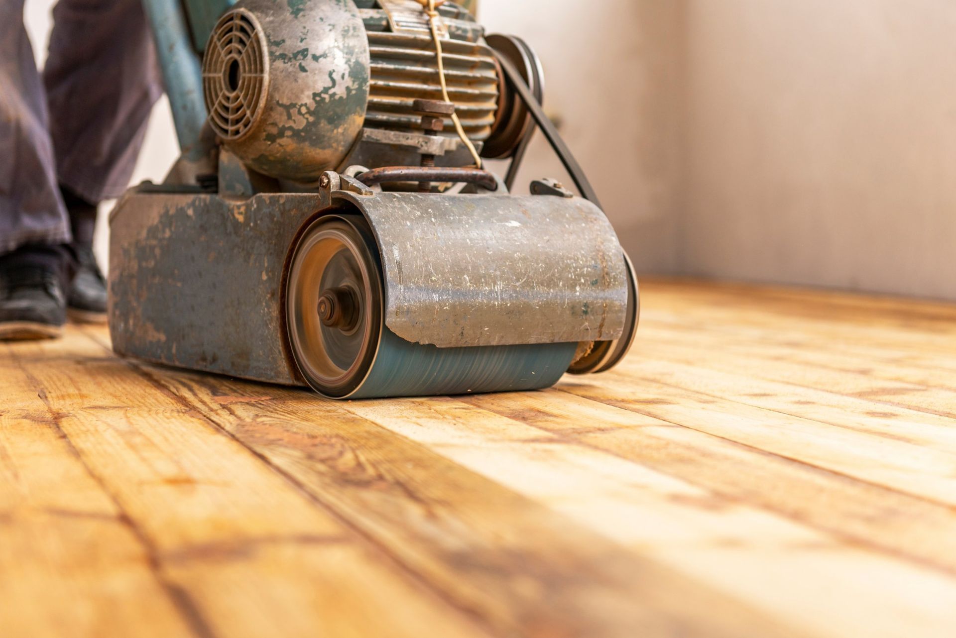 Floor sander smoothing wooden floorboards.