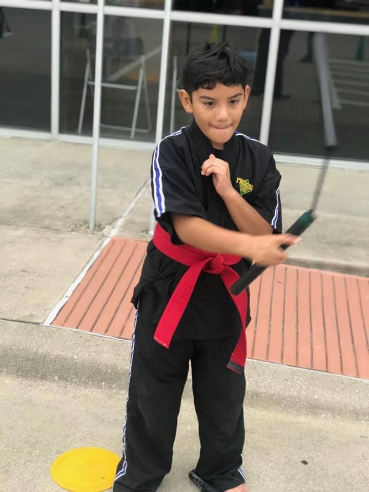 A person is holding a sparkler in their hand in the dark.