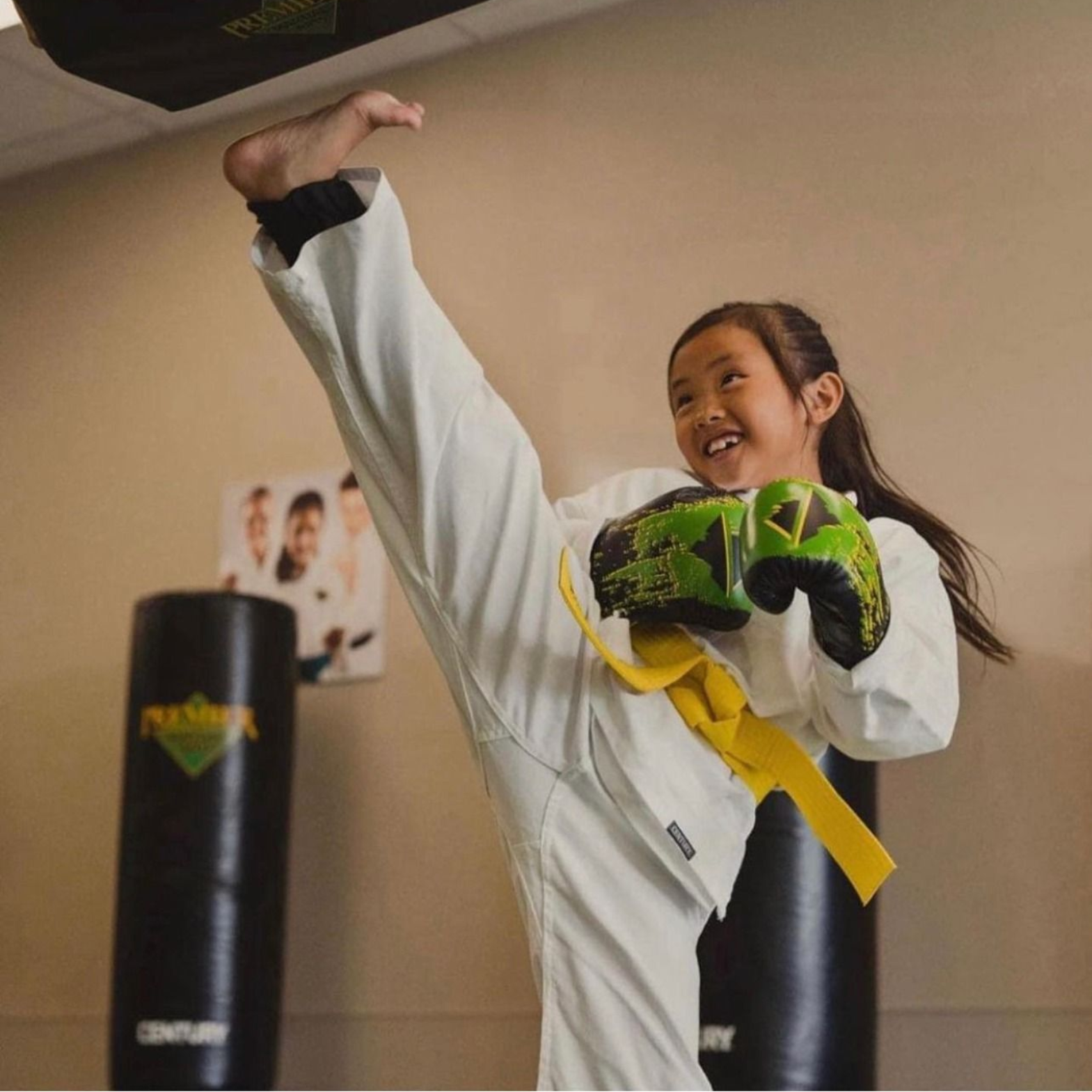 A group of children are practicing karate with a teacher in a gym.