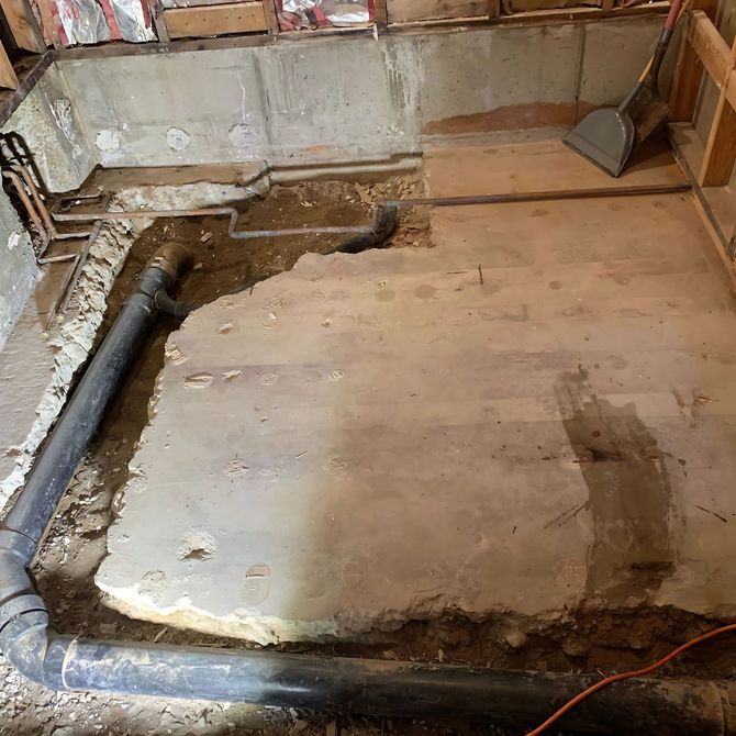 Blue Mountain Contractors LLC - A room with a lot of pipes and a shovel on the floor.