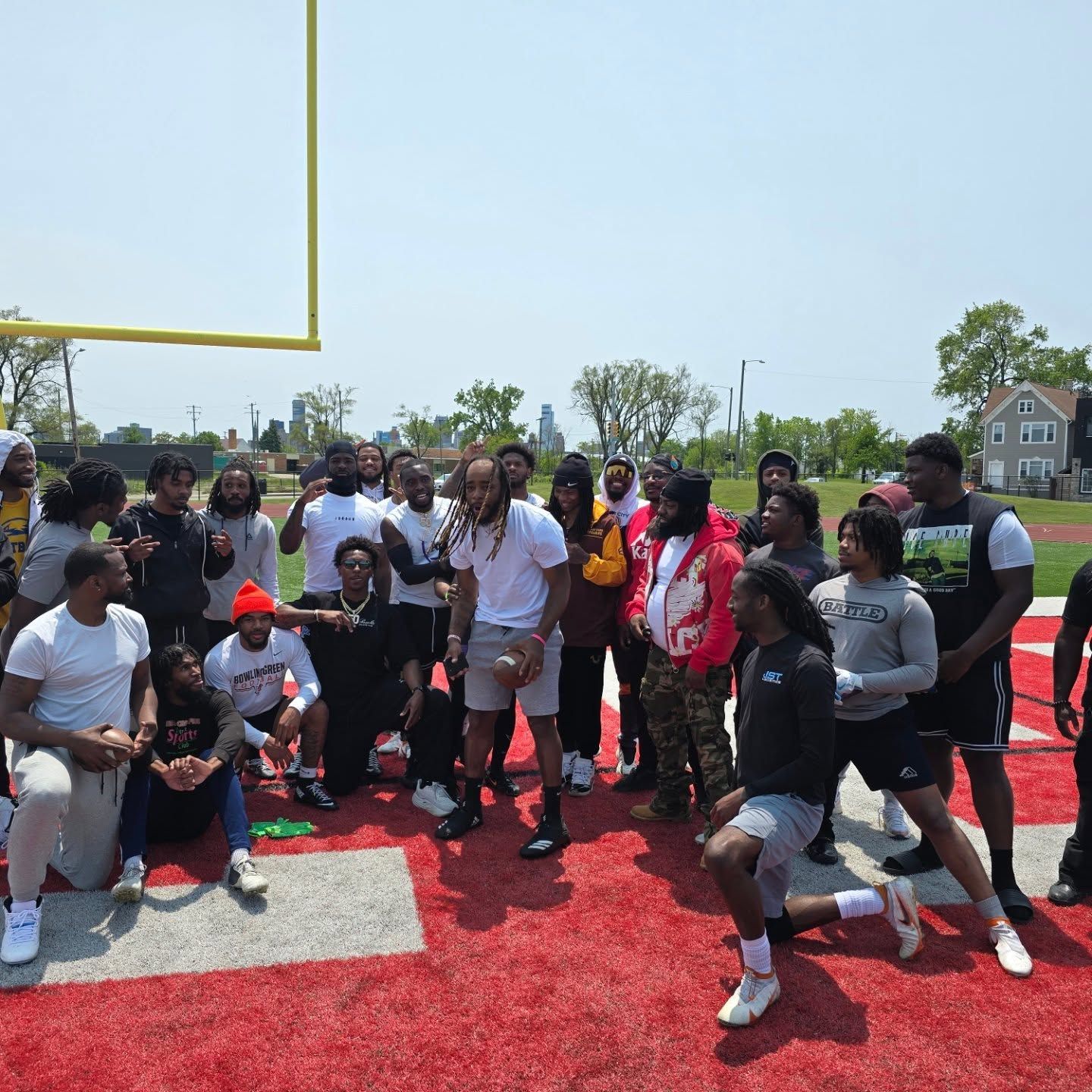 A group of people are posing for a picture on a football field