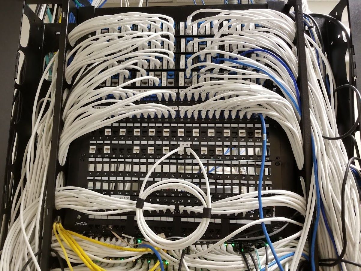 A bunch of wires are connected to a server rack
