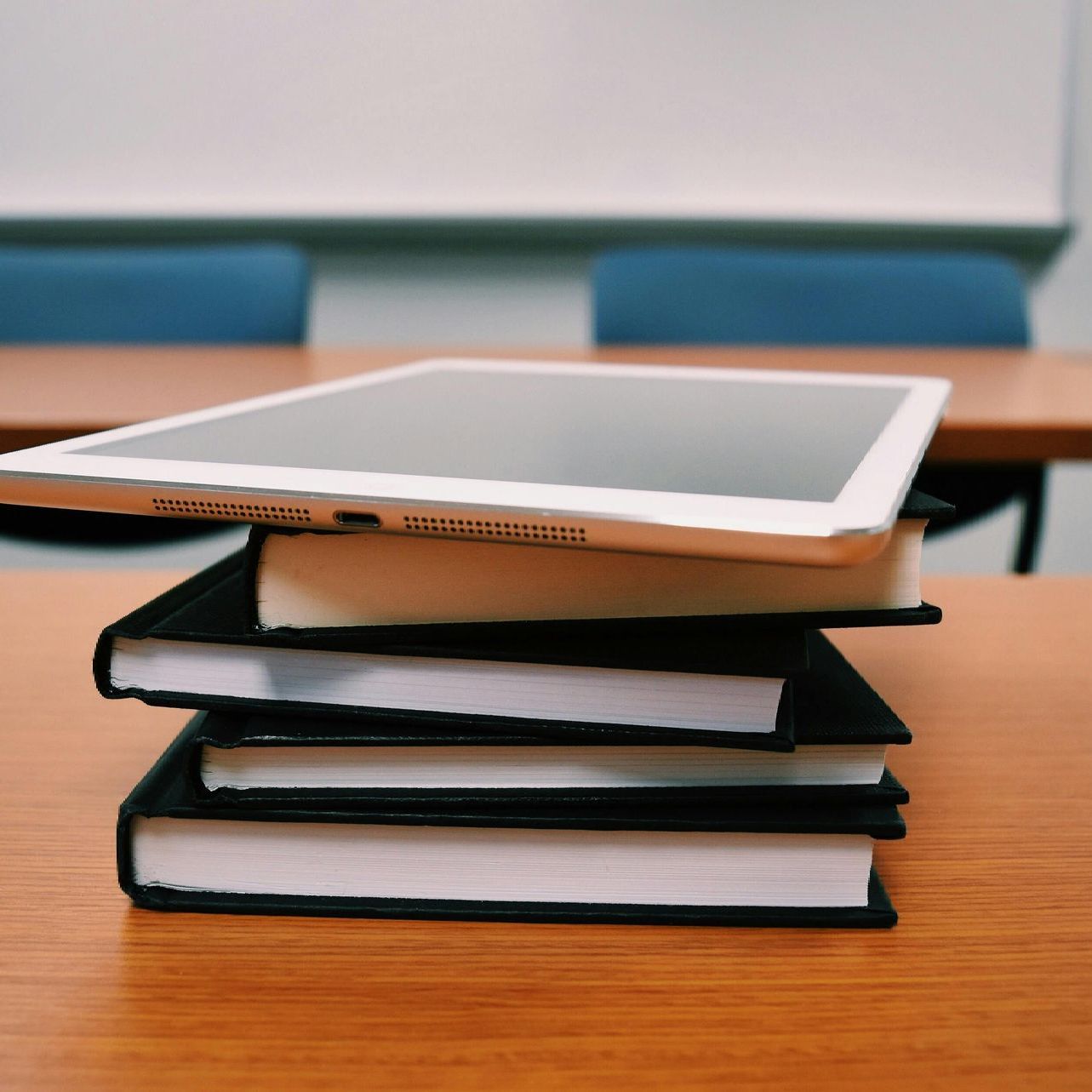 A tablet is sitting on top of a stack of books