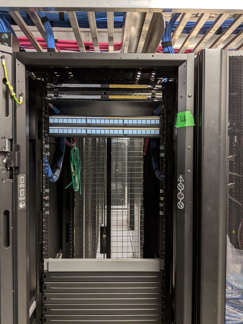 A server rack with a lot of wires coming out of it.