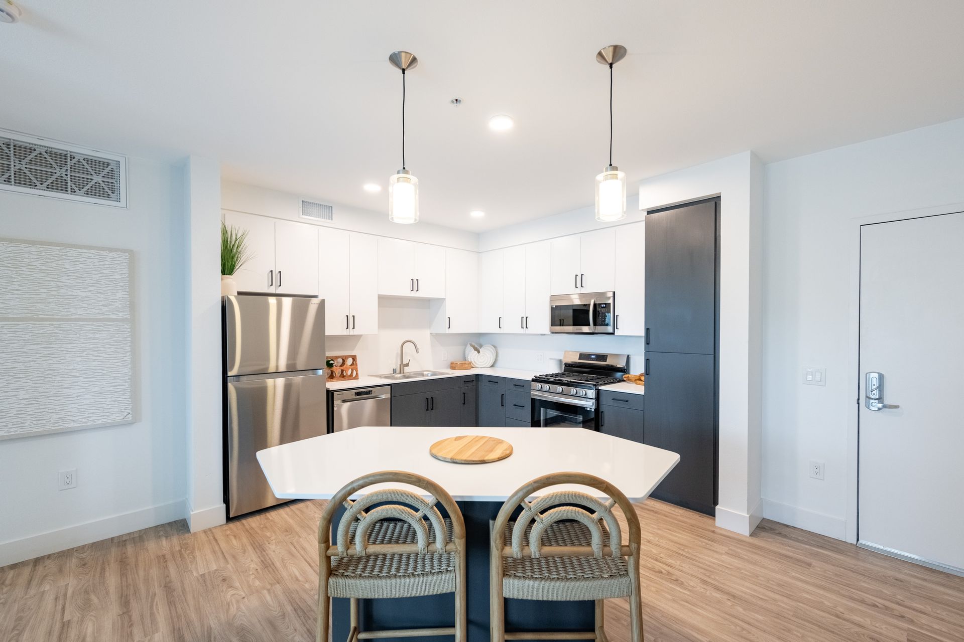 A kitchen with stainless steel appliances and a large island in the middle.