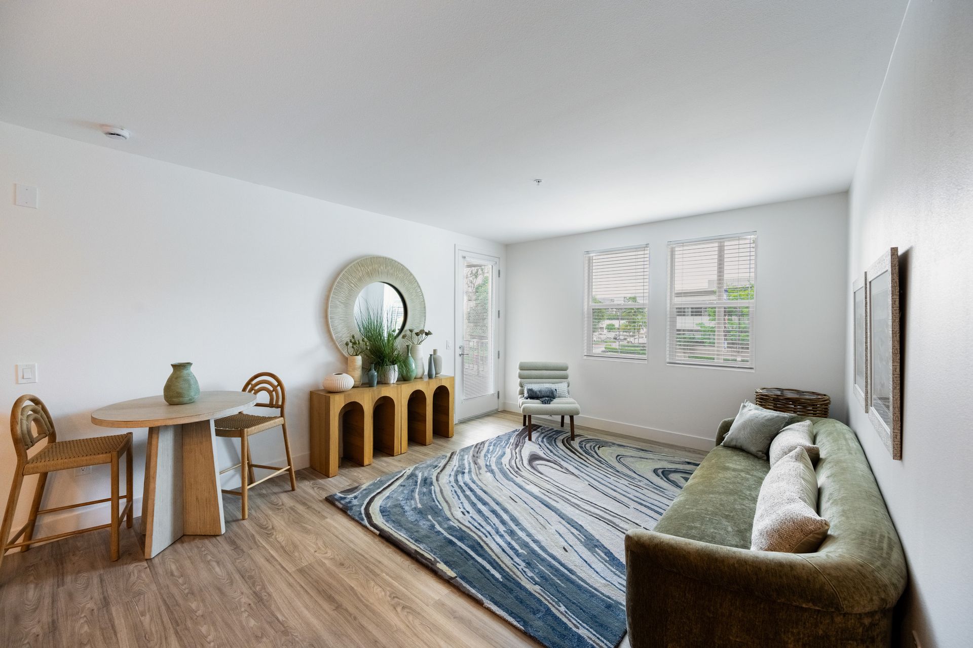 A living room with a couch , table , chairs and a rug.