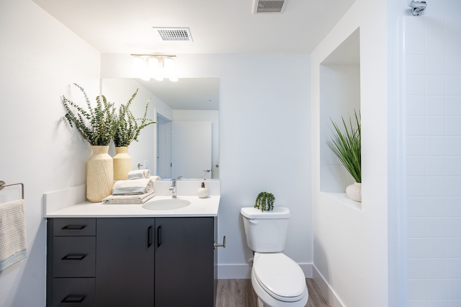A bathroom with a toilet , sink and mirror.