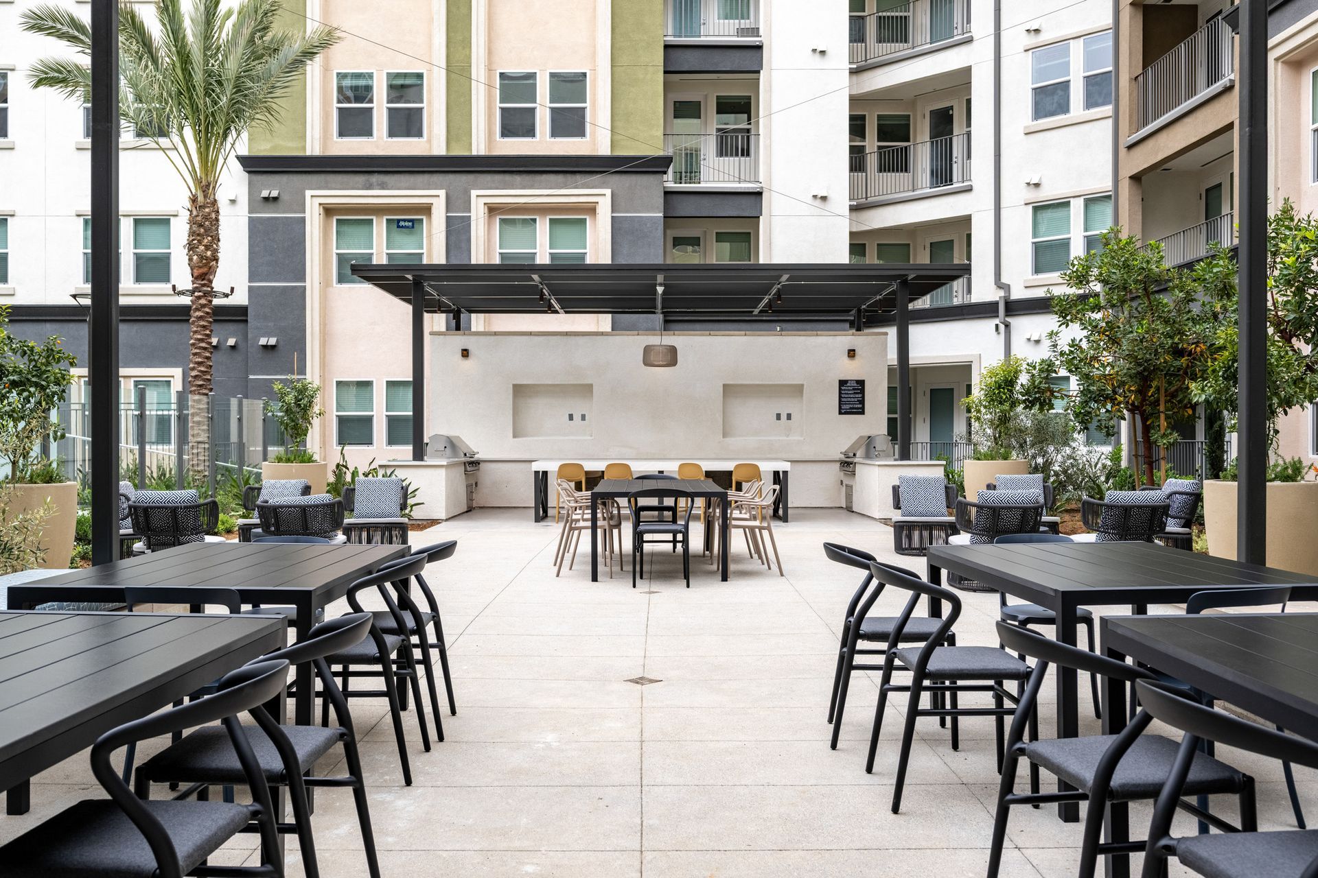 A patio with tables and chairs in front of a building.