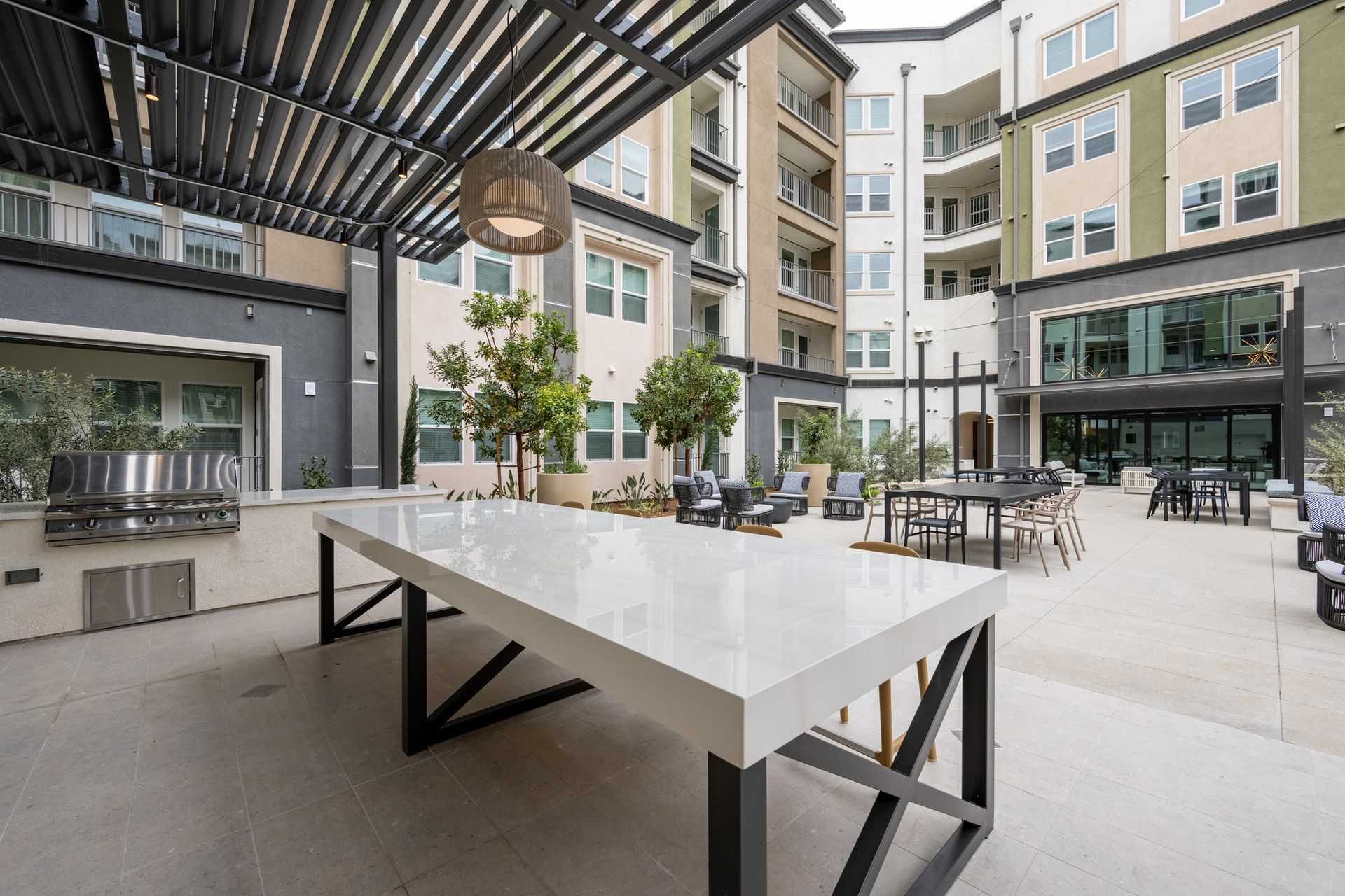 A ping pong table is in the middle of a courtyard in front of a building.