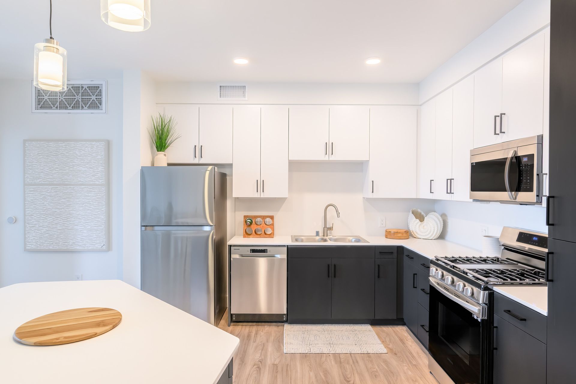 A kitchen with black cabinets and stainless steel appliances.