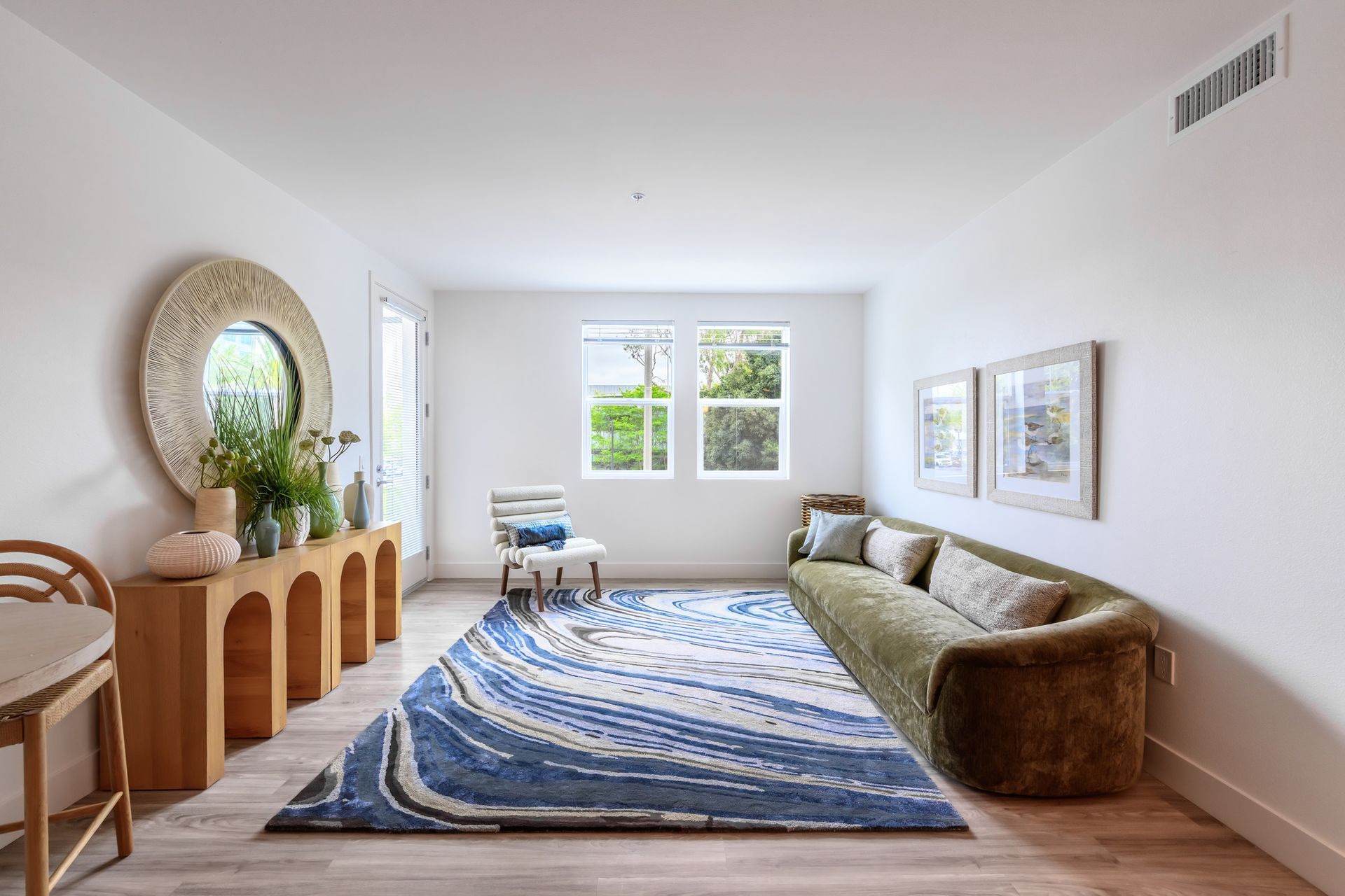 A living room with a green couch and a blue rug.