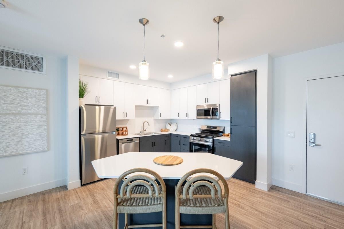 A man is sitting on the floor listening to music on a record player.