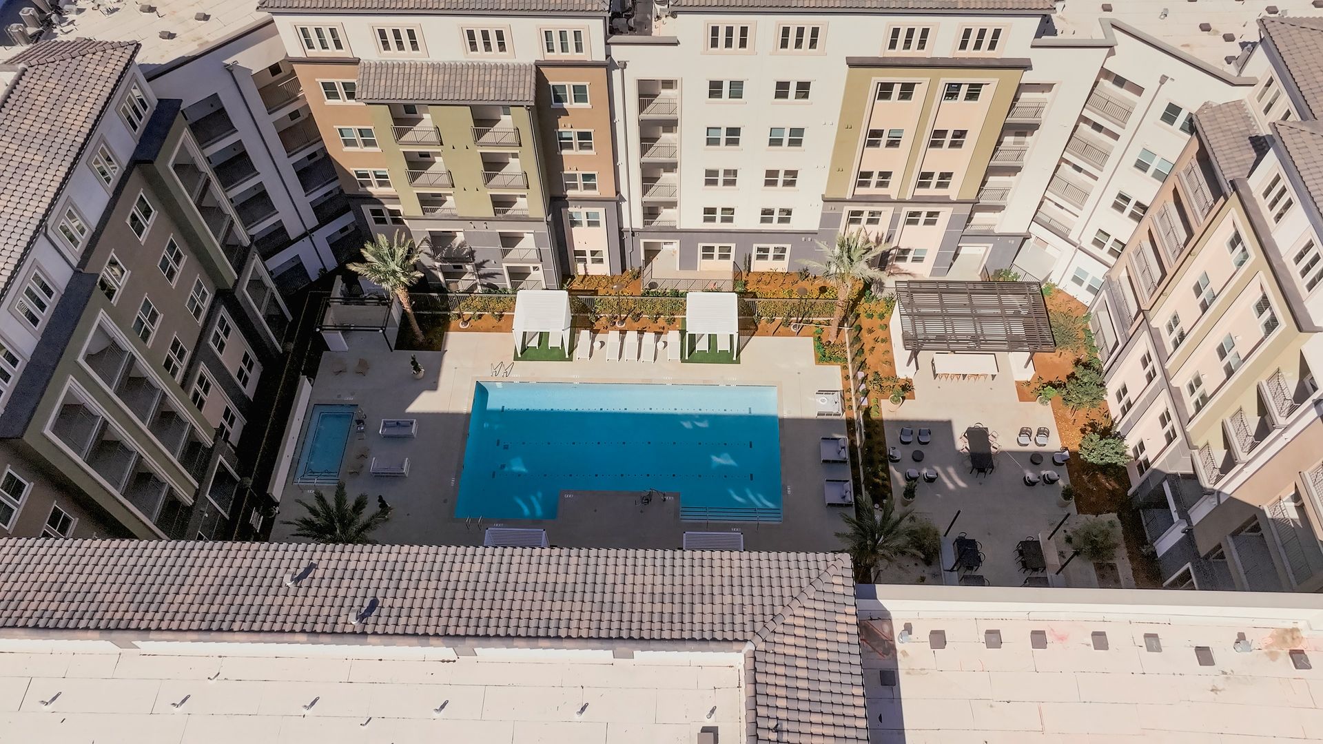Aerial view of The ENZO  with a pool, lounge chairs, and central courtyard. 