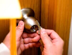 Person holding a key and the doorknob — Locks in Denver, CO
