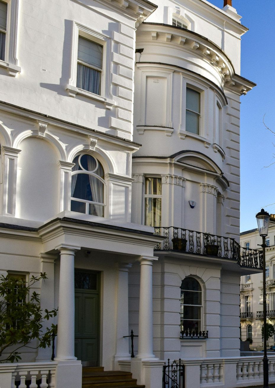 White stucco building with ornate architectural details, columns, and arched windows.