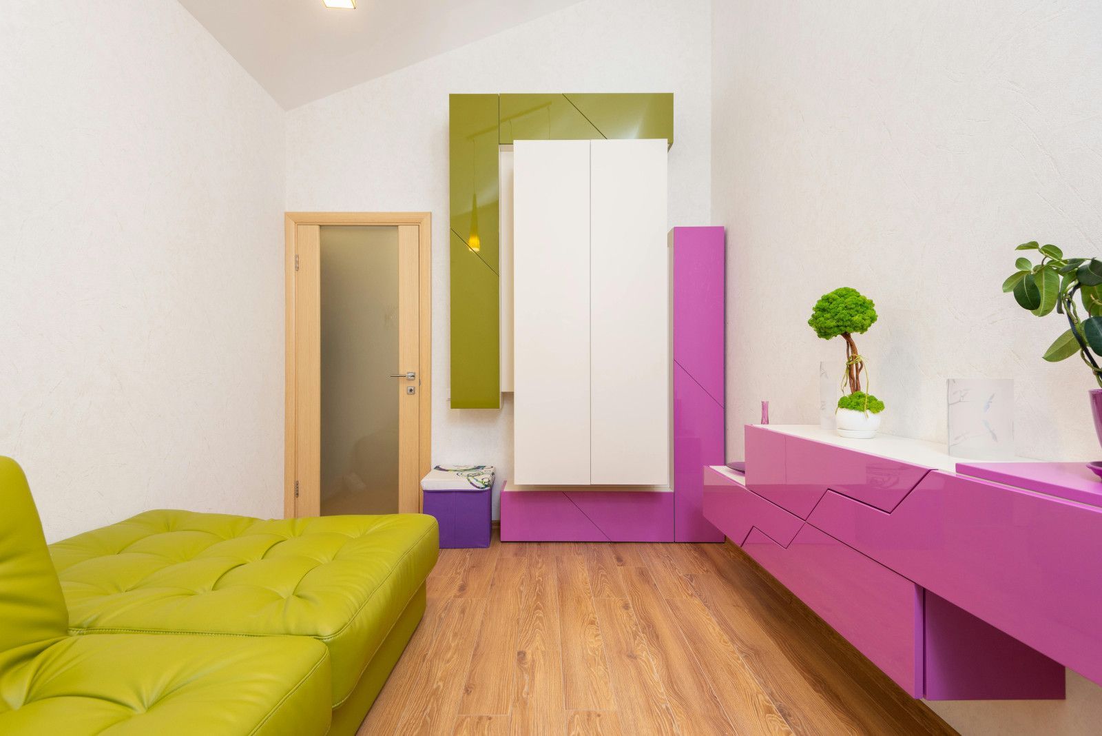 A living room with a green couch and purple furniture.