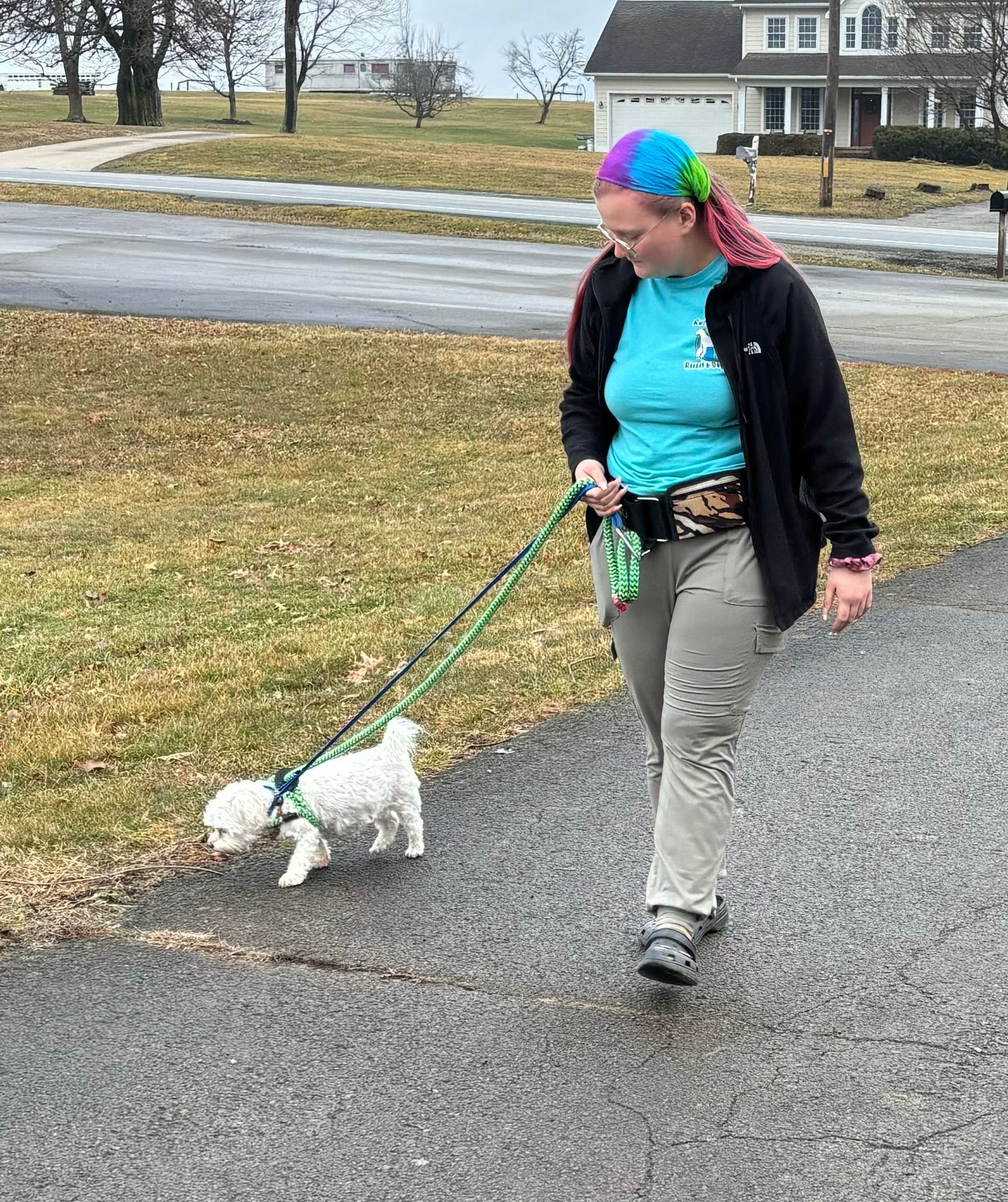 A woman is holding a gray and white cat in her arms.