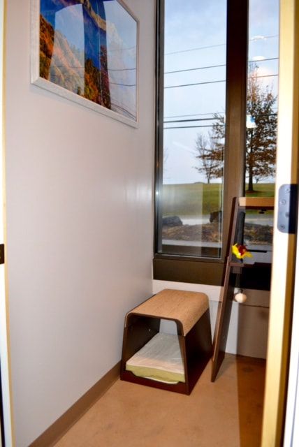 A room with a stool and a picture on the wall