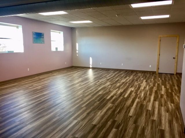 An empty room with wooden floors and pink walls