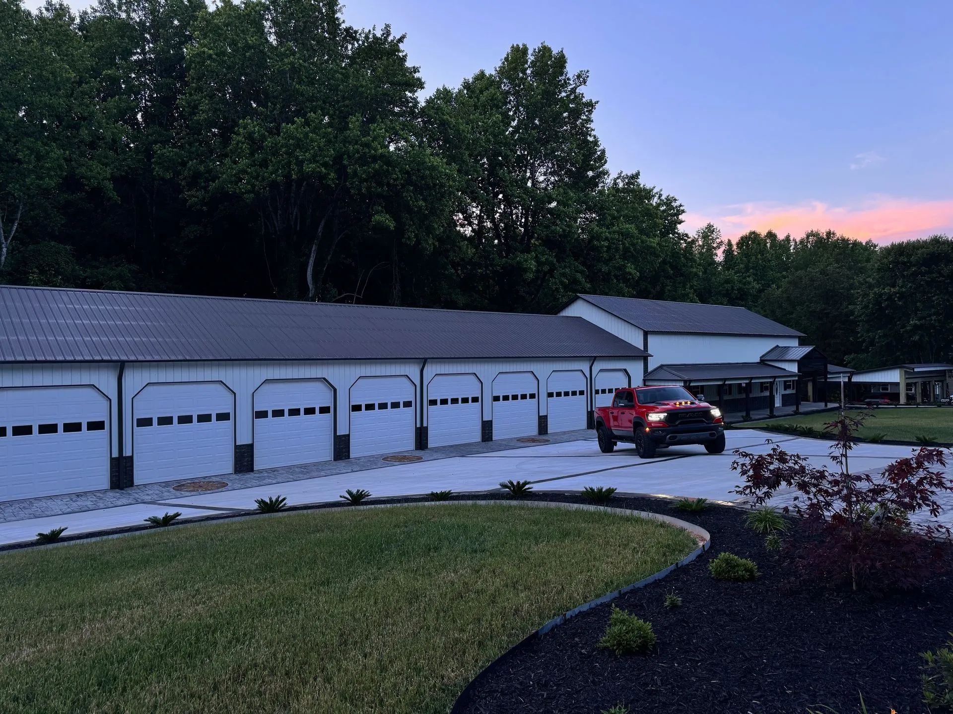 A red truck is parked in front of a garage.