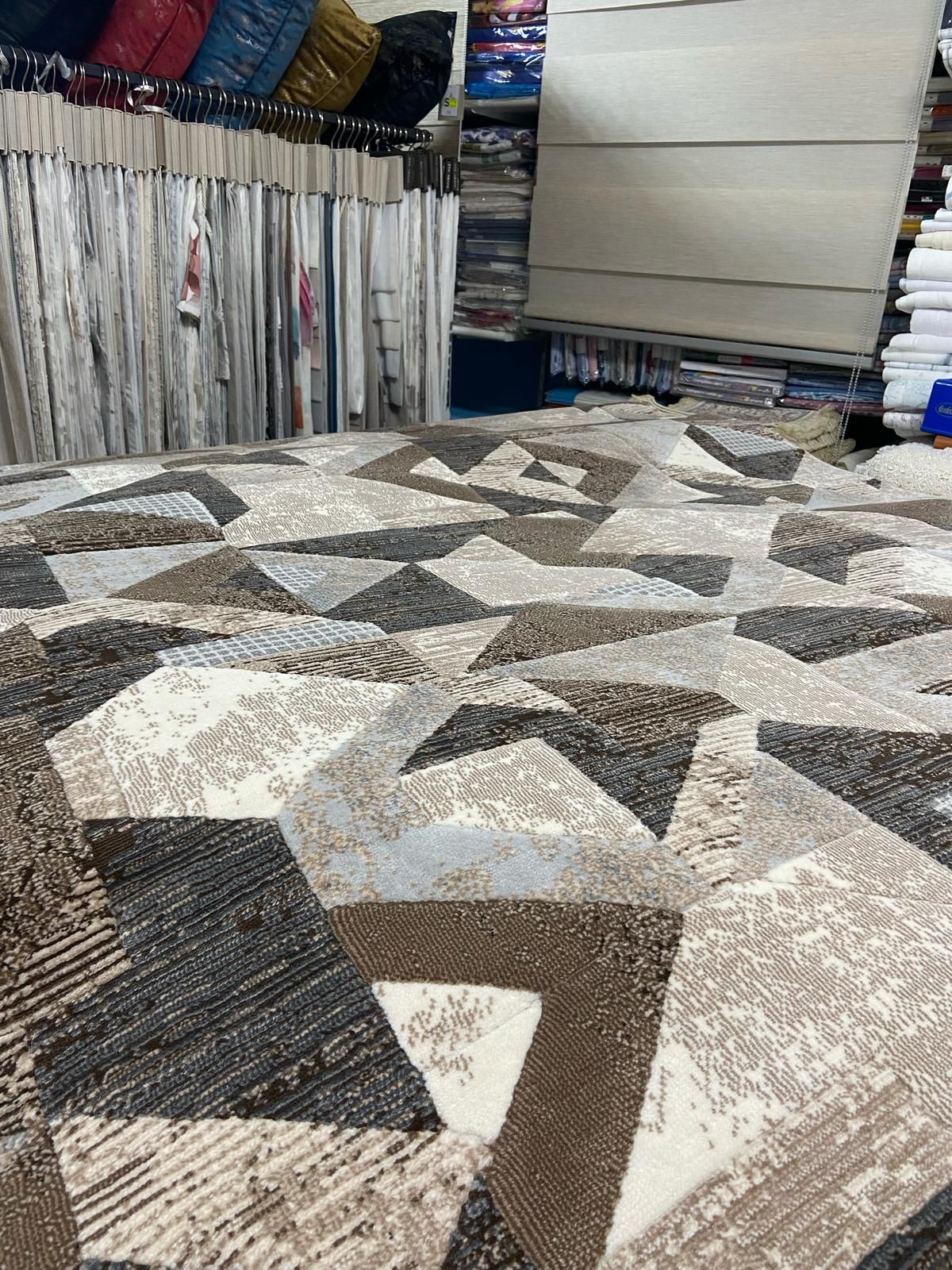 Un tappeto con un motivo geometrico è appoggiato su un tavolo in un negozio.