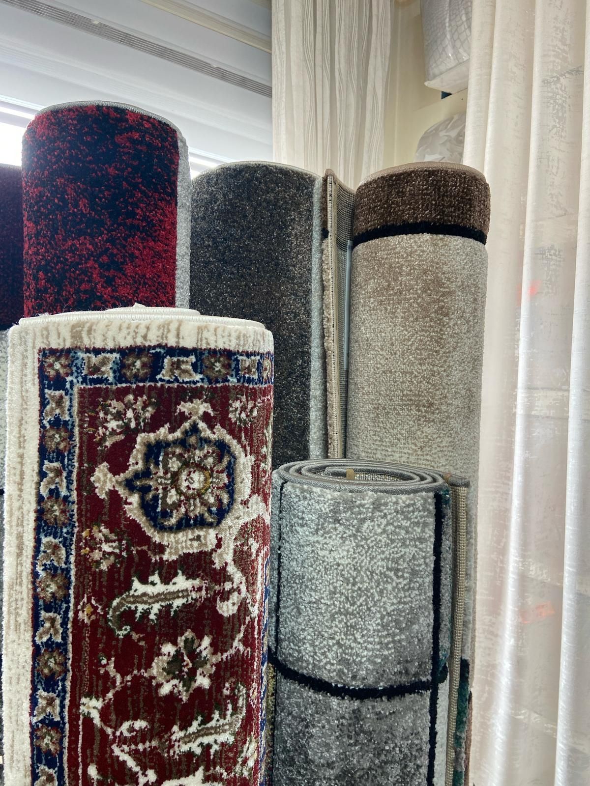 Un mucchio di tappeti sono accatastati uno sopra l'altro in una stanza.