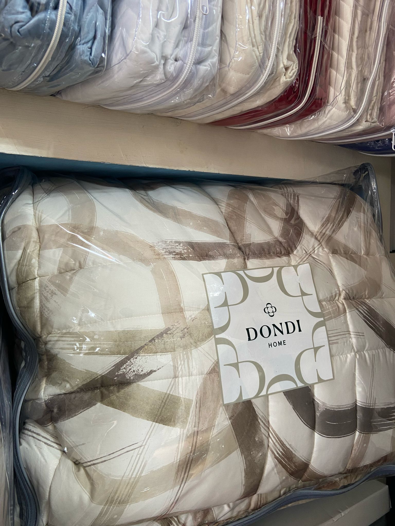 Una pila di coperte sistemate una sopra l'altra su uno scaffale.