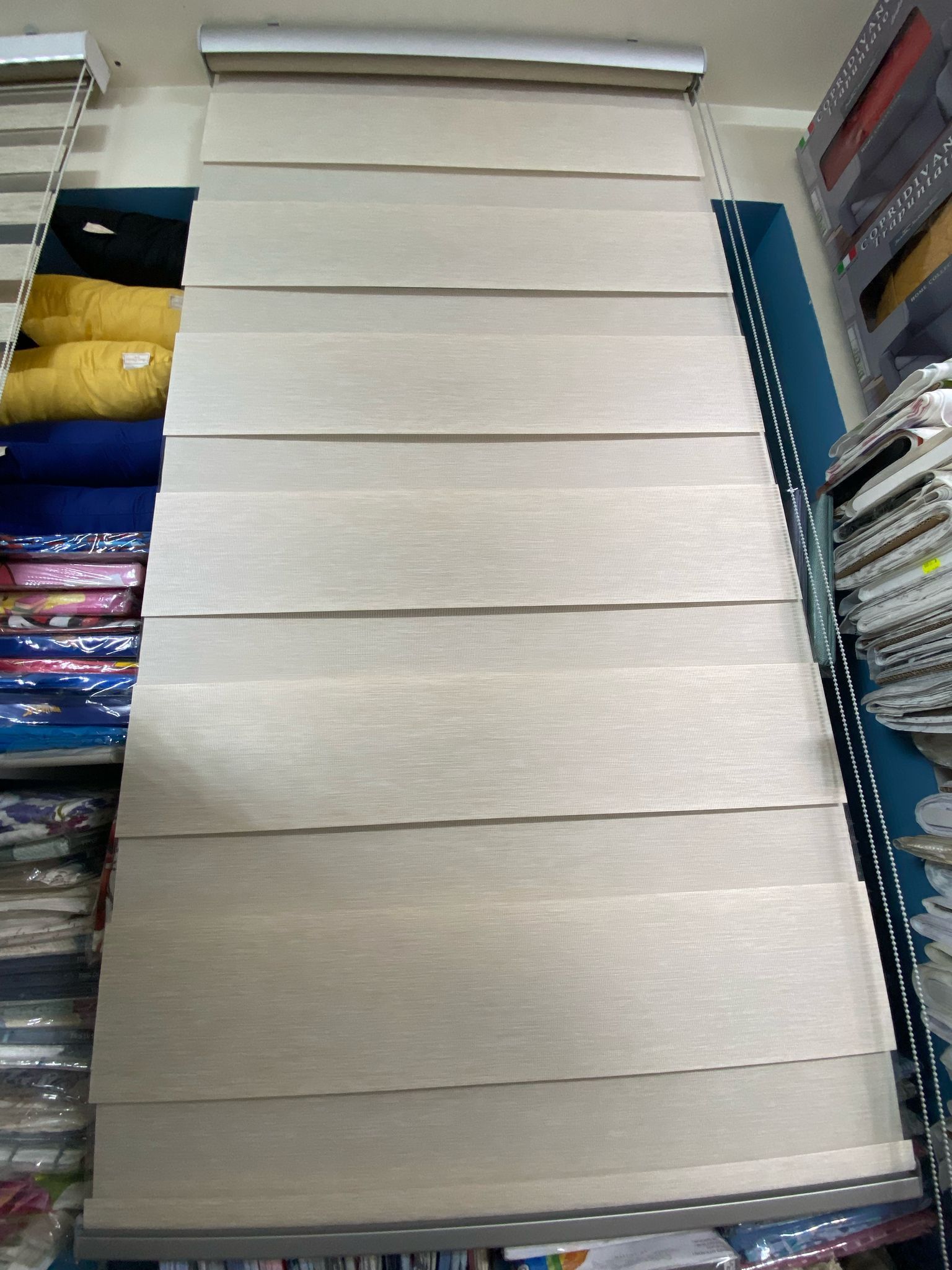 Una tenda bianca è appesa al muro di un negozio.