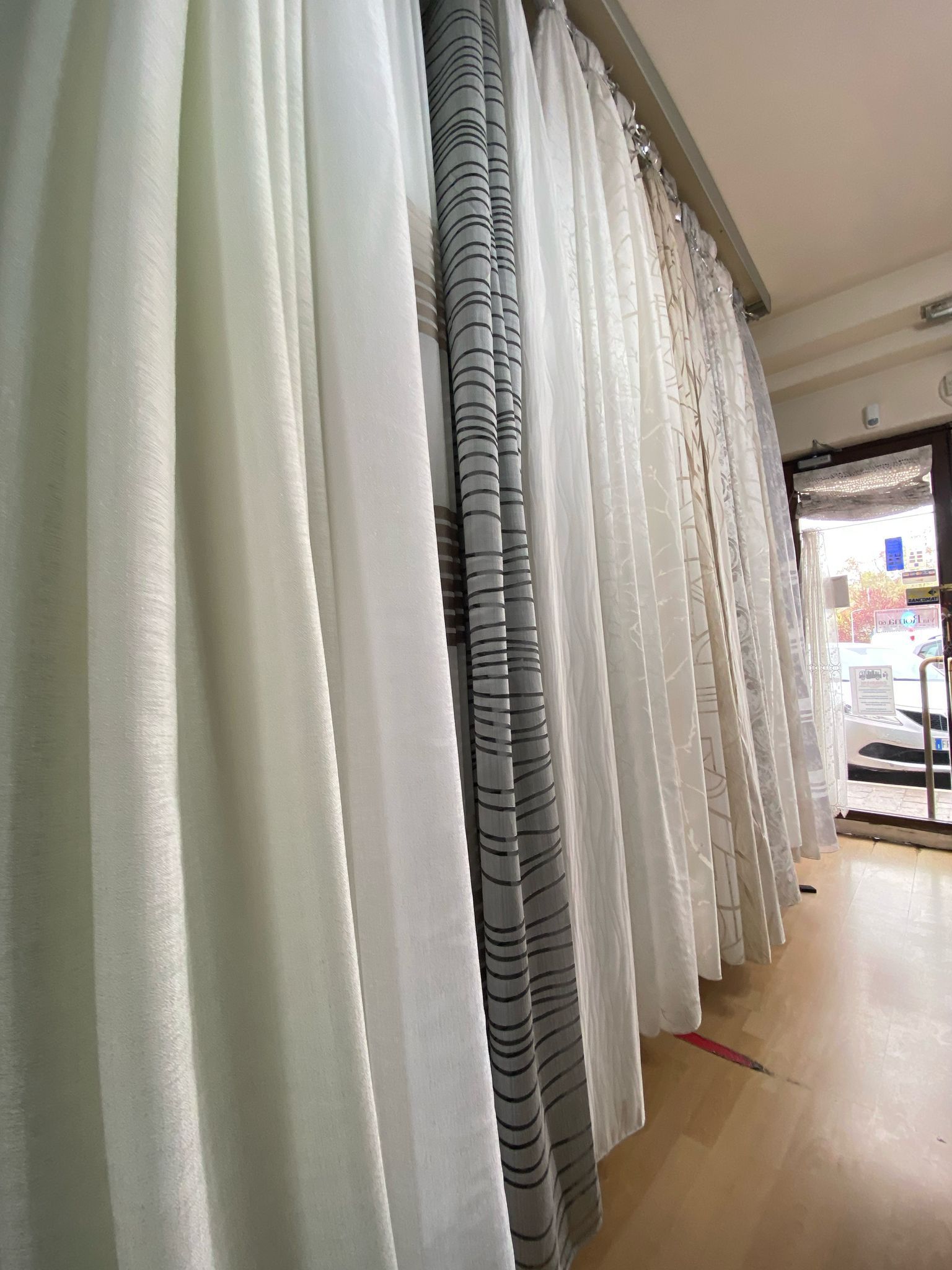 Una fila di tende bianche è appesa a una parete in una stanza