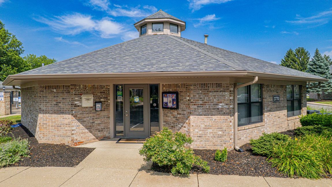 Brick building with a circular roof and a small cupola on a sunny day.
