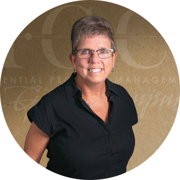 Woman with glasses, and black shirt, in front of a golden background with text.