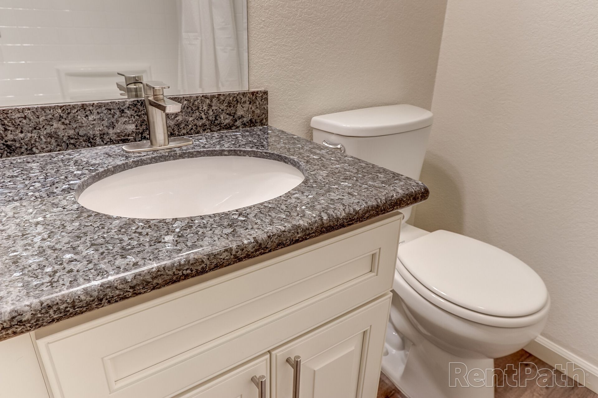 A bathroom with a sink , toilet and mirror