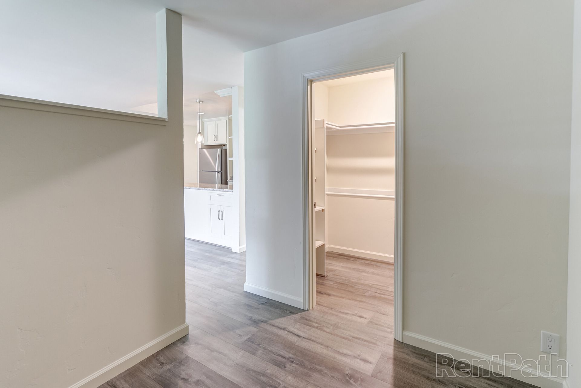 An empty room with hardwood floors and a walk in closet.