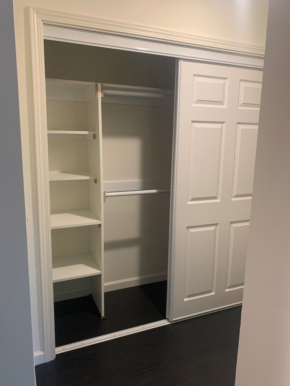 A closet with sliding doors and shelves in a room.