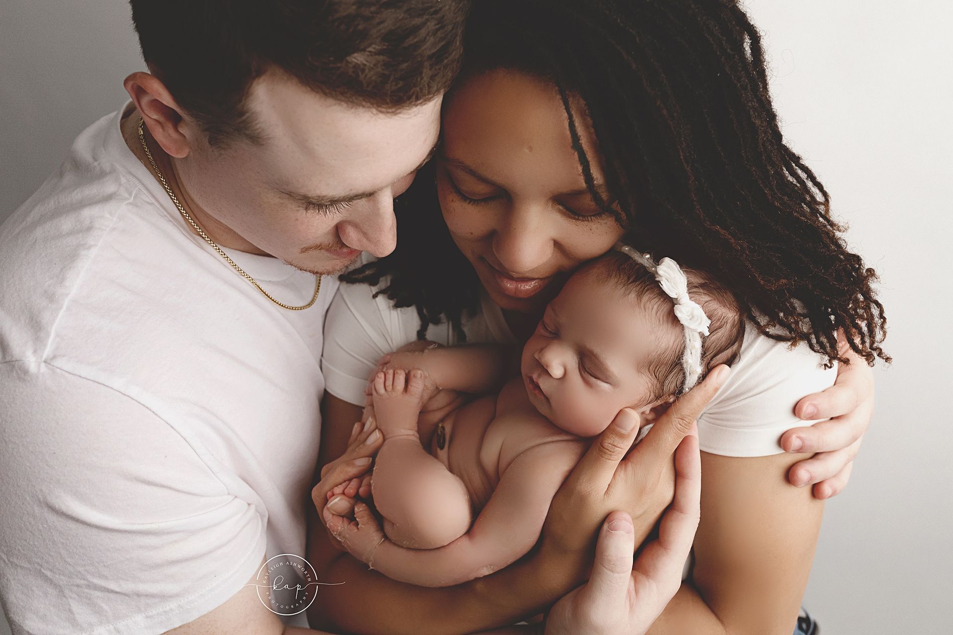 A man and woman are holding a newborn baby in their arms.