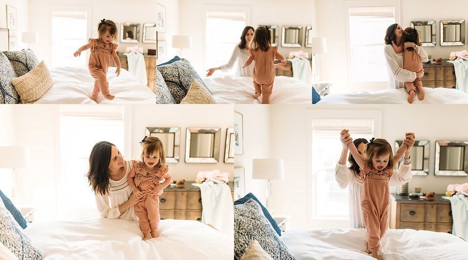 A woman and a little girl are playing on a bed.