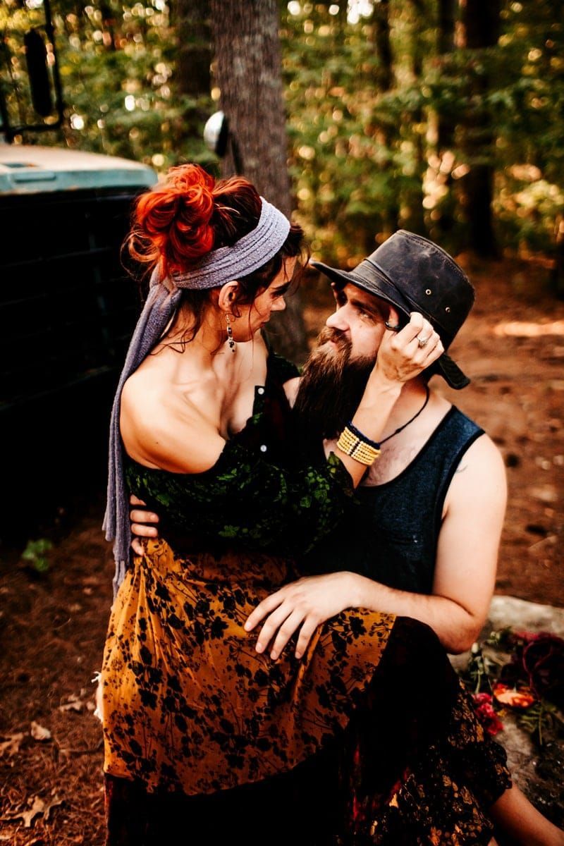 A man and a woman are sitting next to each other in the woods.