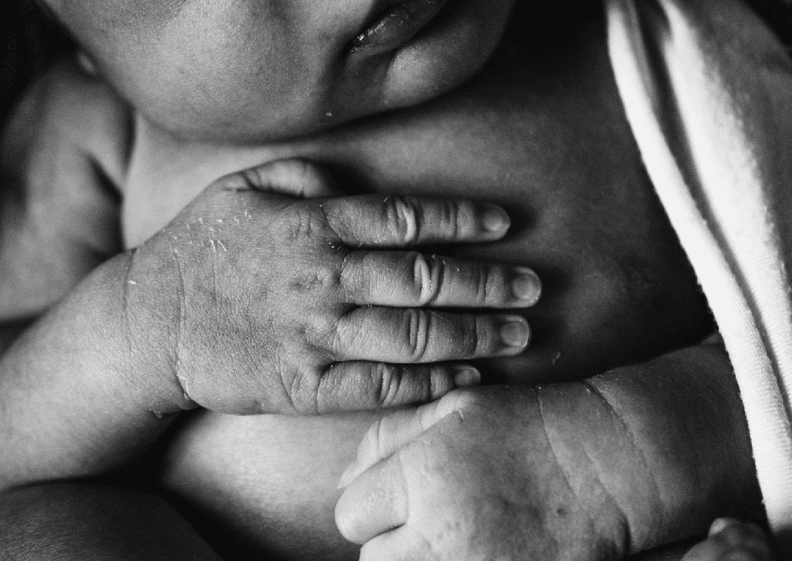 A black and white photo of a person holding a baby