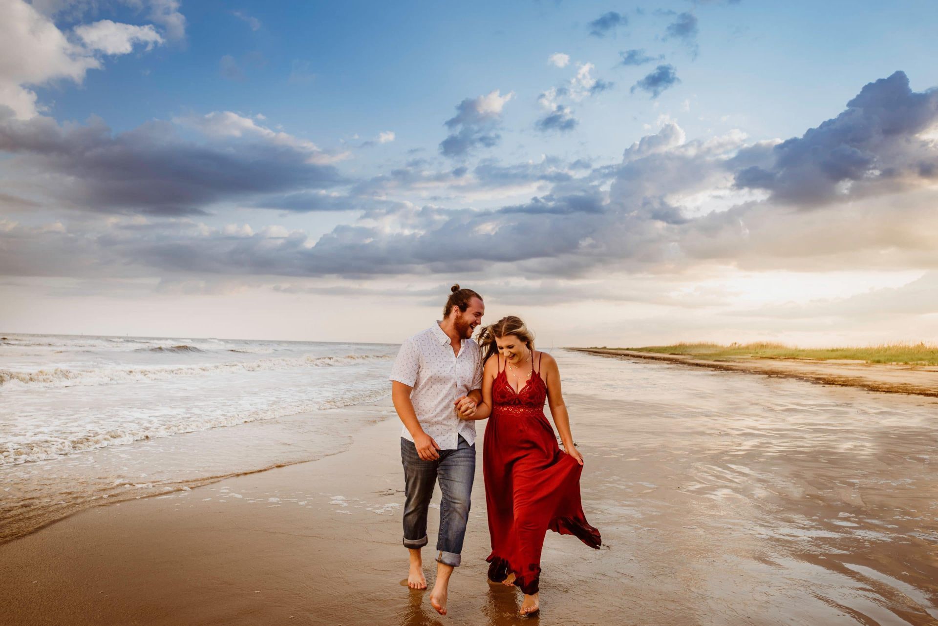 A man and a woman are walking on the beach.