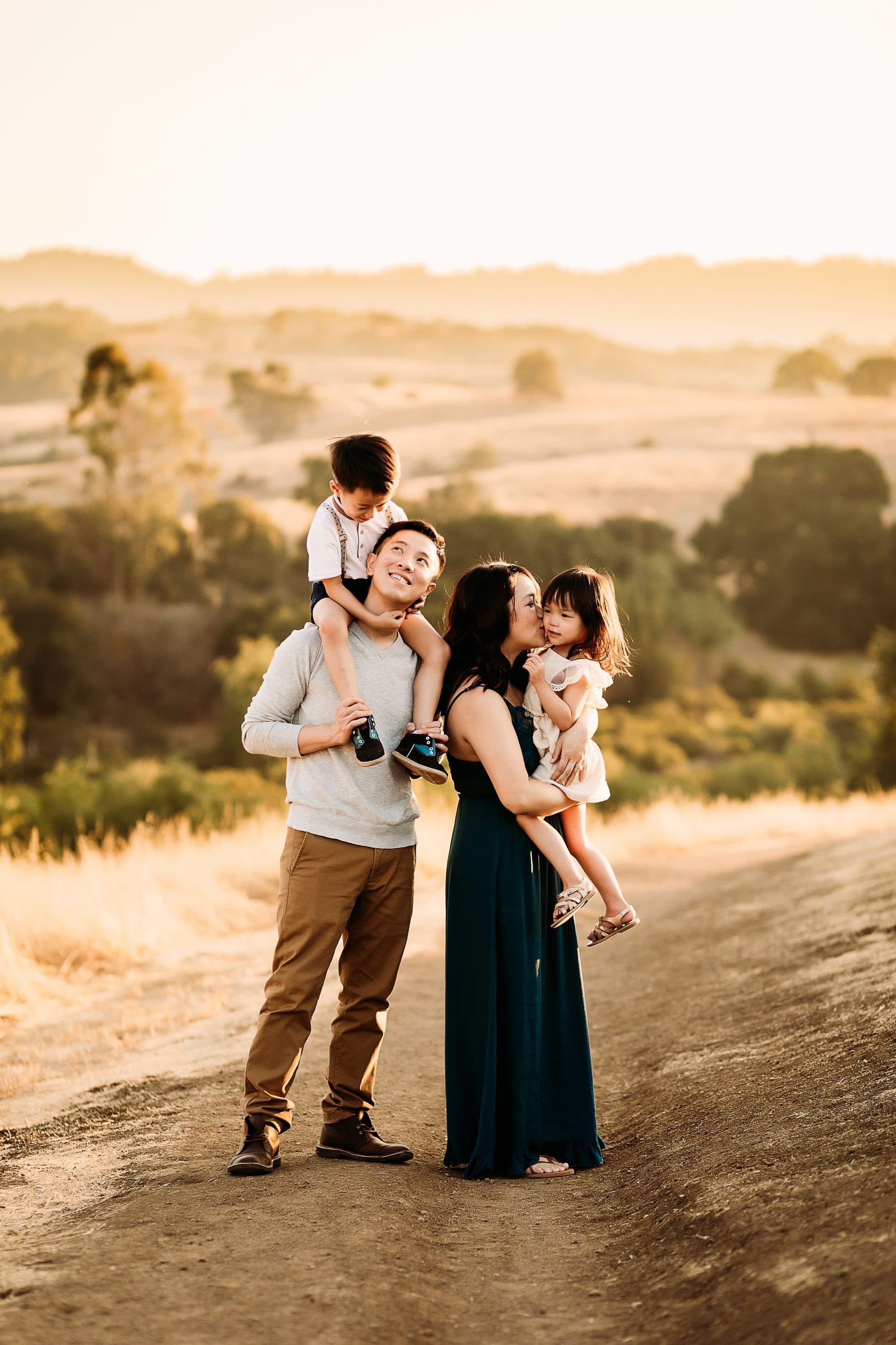 A family is standing next to each other on a dirt road.