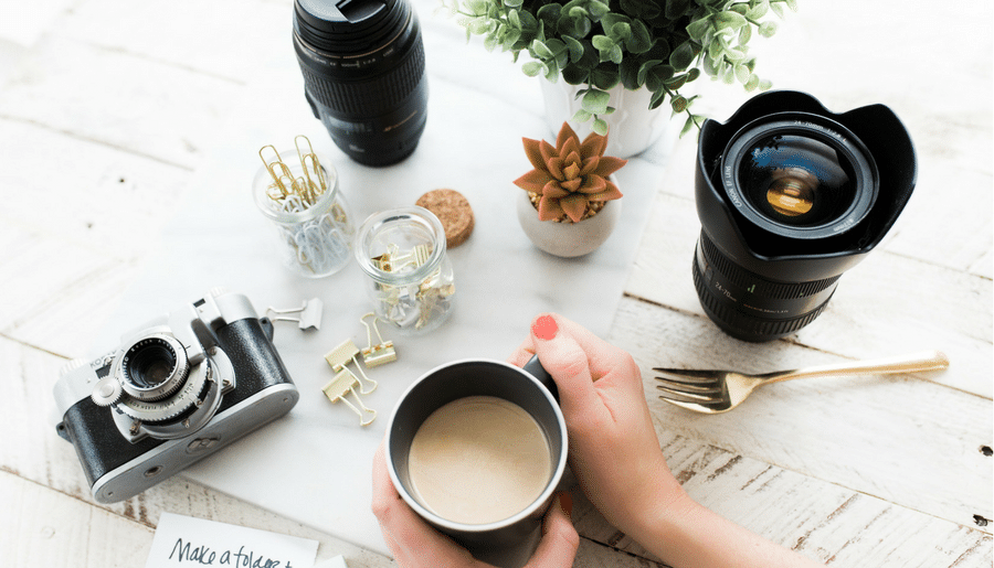 A person is holding a cup of coffee in front of a camera.