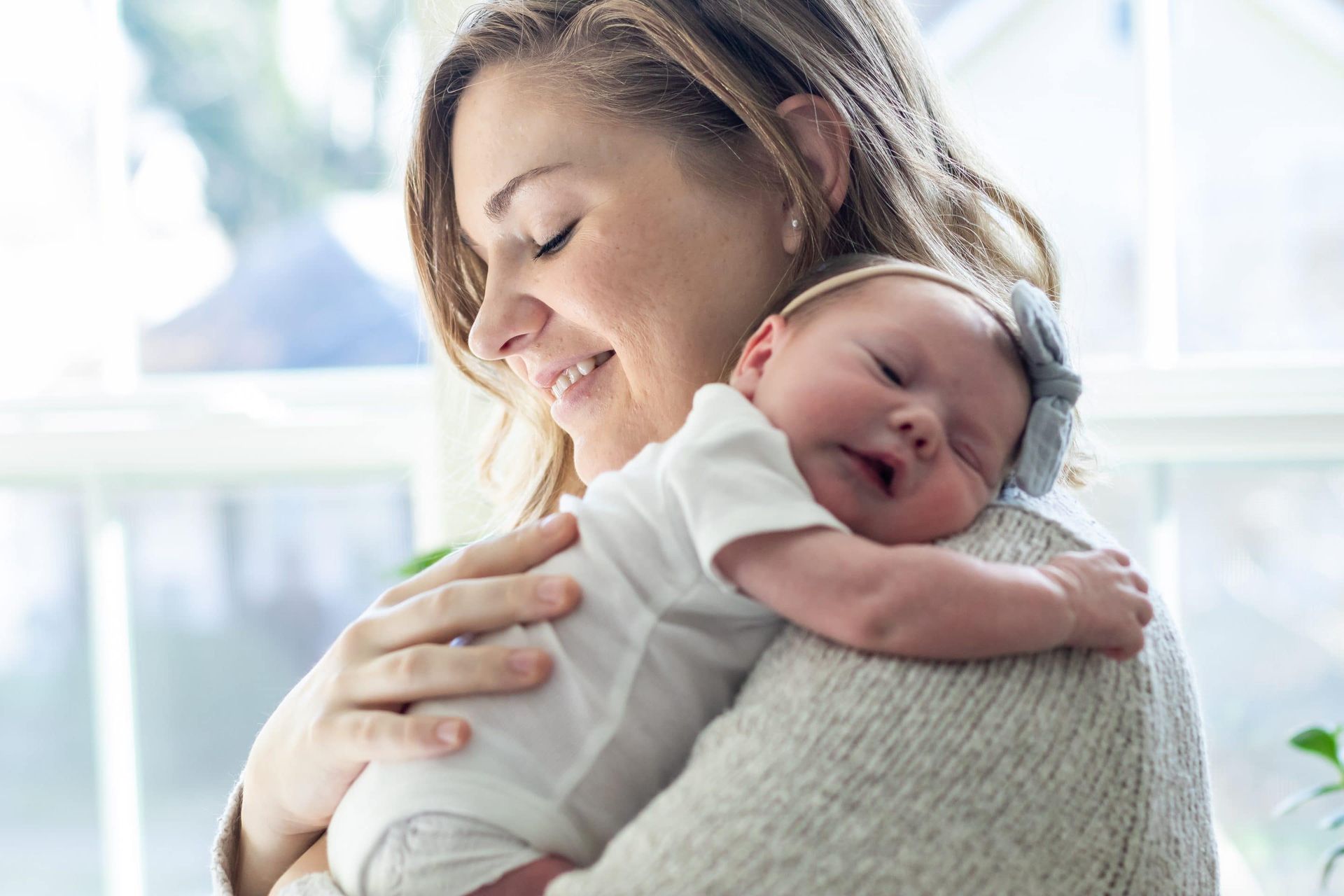 A woman is holding a newborn baby in her arms.